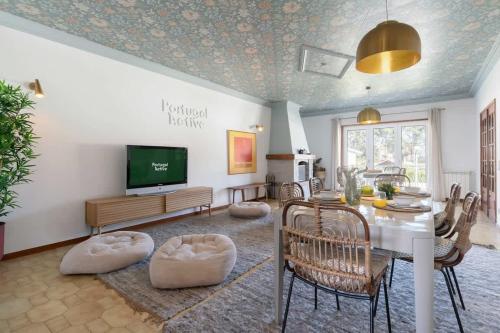 a living room with a dining table and a television at Portugal Active Cabedelo Beach Lodge - Heated Pool in Viana do Castelo
