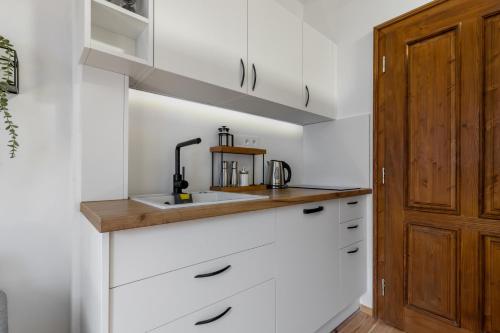 a kitchen with white cabinets and a sink at Apartmán TICHO - Ostrůvek in Lesná