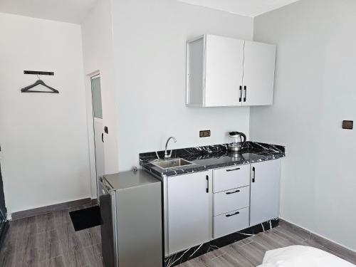 a white kitchen with a sink and a counter top at Chambre d'hôte plage Dalia in Dalia