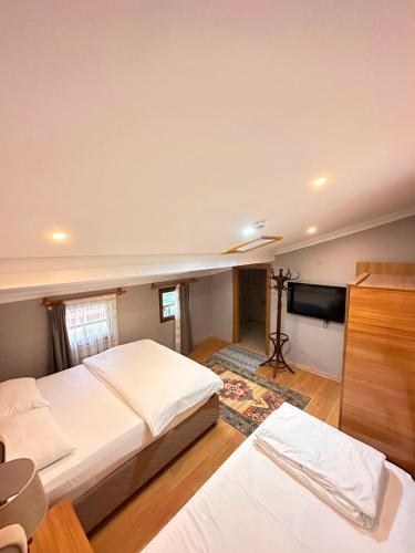 a bedroom with two beds and a flat screen tv at Koç Motel in Uzungöl