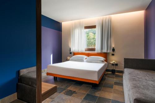 a bedroom with a bed and a window and a couch at Zurafa Resort in Terrauzza