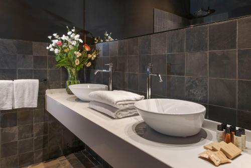 a bathroom with a sink and a vase of flowers on a counter at Zurafa Resort in Terrauzza
