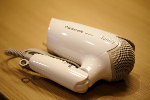 a hair dryer sitting on top of a wooden table at Hotel Monte Hermana Fukuoka in Fukuoka