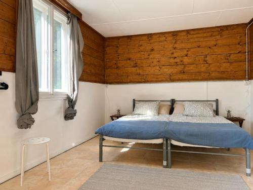 a bedroom with a bed with a wooden wall at Gedeon Garden in Budakalász