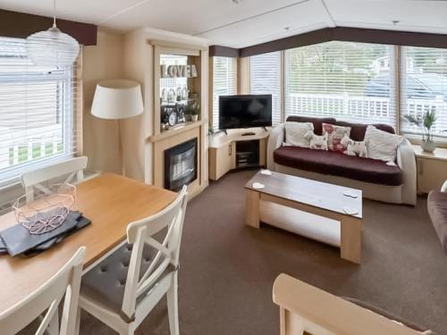 a living room with a couch and a table at 86 Cader Idris in Pwllheli