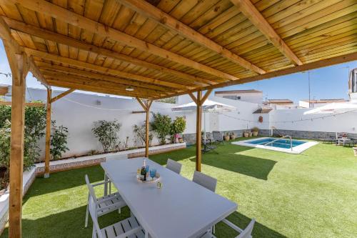 a patio with a white table and chairs and a pool at MalagaSuite Villa Flor de Piedra in Fuente de Piedra