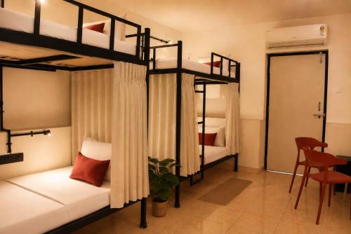 two bunk beds in a room with a table at 8fold by Larisa, Siolim in Siolim