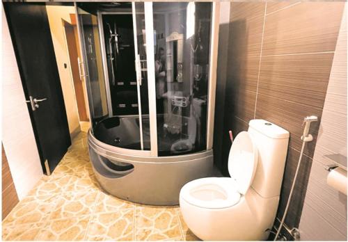 a bathroom with a toilet and a bath tub at CRISPAN SUITES & EVENT CENTRE in Jos