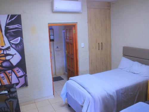 a bedroom with two beds and a door to a bathroom at Kat Guest house in Northam