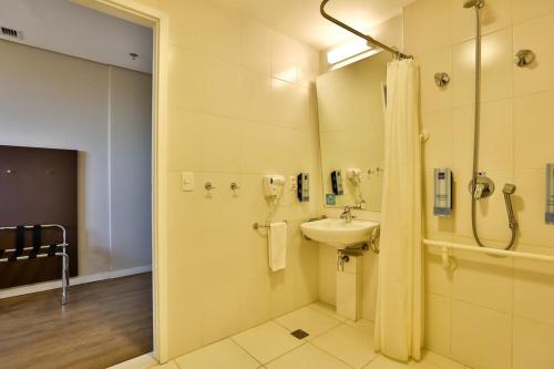 a bathroom with a sink and a shower at Summit Suítes Hotel Pindamonhangaba in Pindamonhangaba