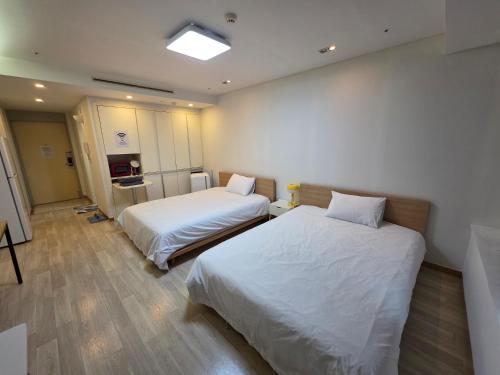 a hospital room with two beds and a television at Incheon Airport Yeongjong Guesthouse in Incheon