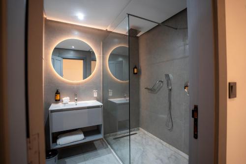 a bathroom with a shower and a sink and a mirror at Le Rio Appart-Hotel City Center in Tangier