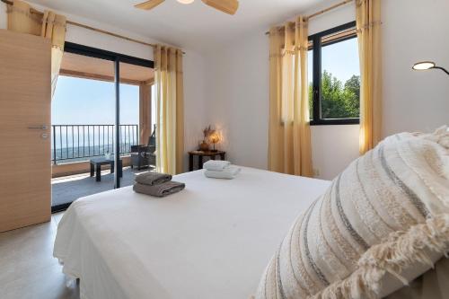 a bedroom with a large bed and a balcony at Casa Alena in Cervione