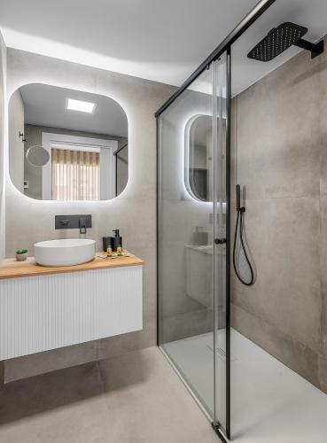 a bathroom with a shower and a sink and a mirror at Pinatar Luxury in San Pedro del Pinatar