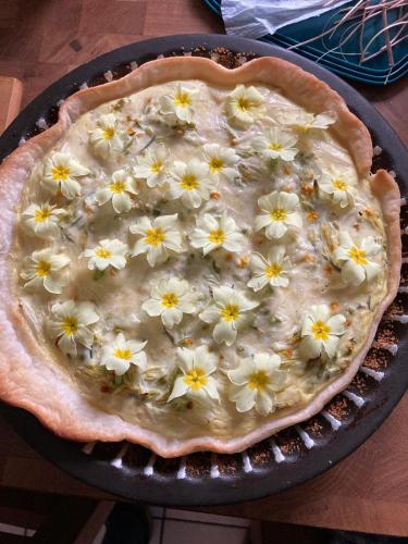 a pie with flowers on top of it in a pan at le Refuge de Pia in Piégut-Pluviers
