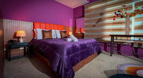 a purple bedroom with a bed and a table at Bellas Artes Palace Secret Suites Adult Only in Santiago