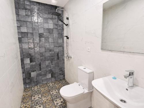 a bathroom with a toilet and a sink and a mirror at Garslyan Boutique Hotel in Ninotsminda