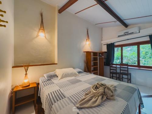 a bedroom with a bed with towels on it at Pousada Casa Canto das Águas in Icaraí