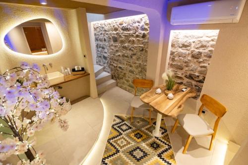 a bathroom with a table and a sink and a mirror at Orama Suite & Spa in Korçë