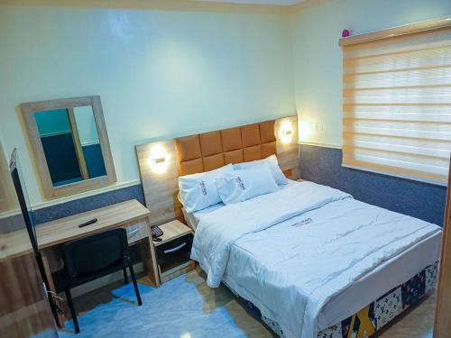 a hotel room with a bed and a television at Amnu Homes Apartment in Ilorin
