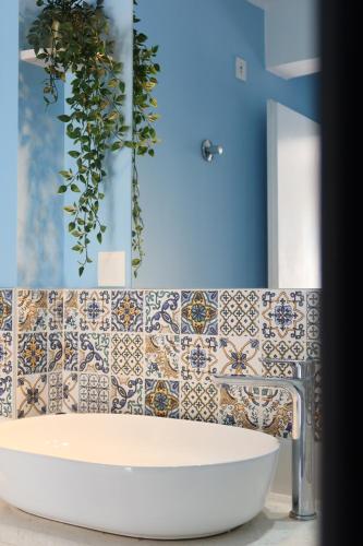 a bathroom with a tub and a tile wall at Apartmani Štambuk in Jelsa