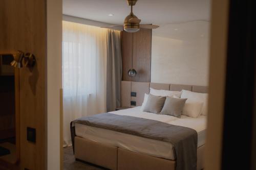ein Schlafzimmer mit einem Bett mit weißen Laken und Kissen in der Unterkunft Sobe Vincentius in Metković