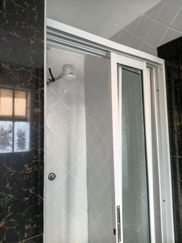 a bathroom with a shower and a glass door at The Sychar Palace Hotel in Kanga