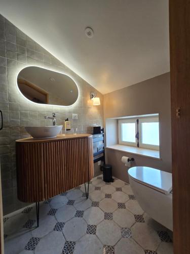 a bathroom with a sink and a toilet and a tub at Hôtel Le Groom in Laprade