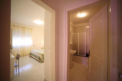 a bedroom with a bed and a bathroom with a toilet at Perla Residence - Salve in Salve