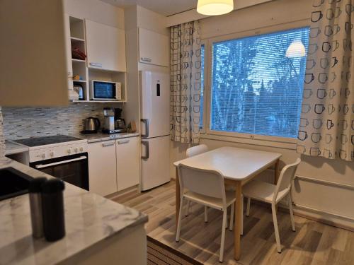 a kitchen with a table and chairs and a window at Annalassa kahden makuuhuoneen asunto in Tampere