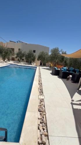 a swimming pool with blue water in a building at ANDA villa&Farm in Amman