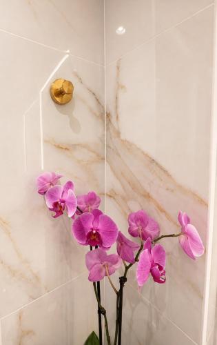a bunch of pink flowers in a vase at Syntagma Spa with Acropolis View in Athens