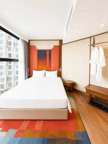 a bedroom with a white bed and a large window at Thanh Son Apartment Mui Ne Beachfront in Ấp Thiẹn Ái