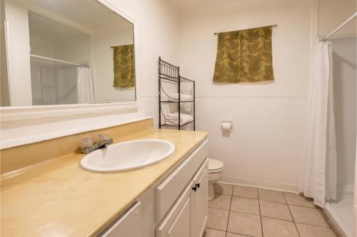a bathroom with a sink and a mirror and a toilet at Oak Motel Modesto CA in Modesto