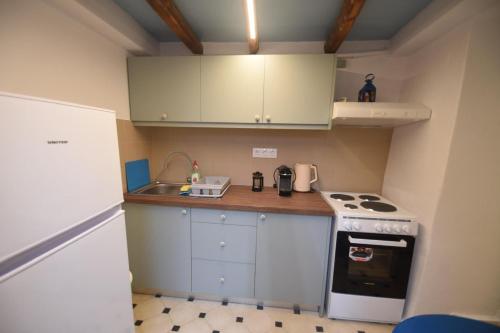 a small kitchen with white cabinets and a stove at Avgonima Joy Medvial Suite in Chios