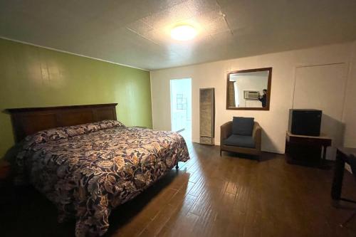 a bedroom with a bed and a chair and a mirror at Oak Motel Modesto CA in Modesto