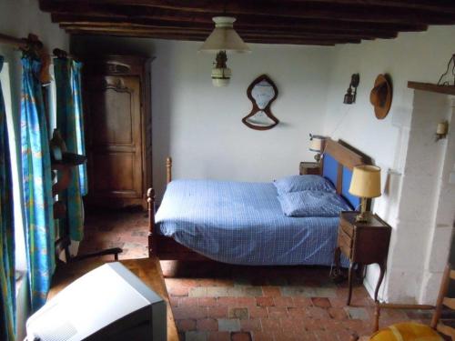 a bedroom with a bed and a tv in it at La Maison du Guetteur in Sancerre