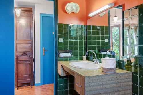 a bathroom with a sink and green tiles at Chambre D'hôtes Le Viel Echalier in Saint-Urbain