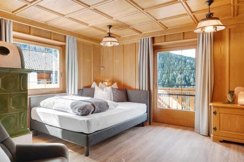 a bedroom with a bed and a large window at Schartenblick in Sarntal