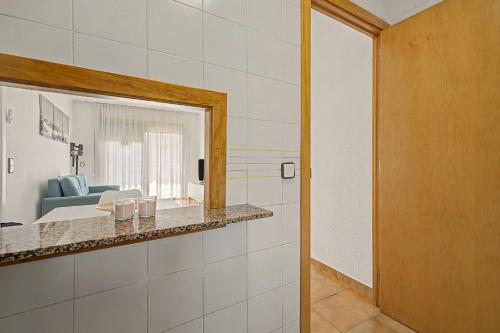 a bathroom with a mirror and a living room at Apartmento CT3 in Salou