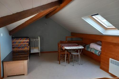 a attic room with a table and a bed at Gîte de montagne in Ventron