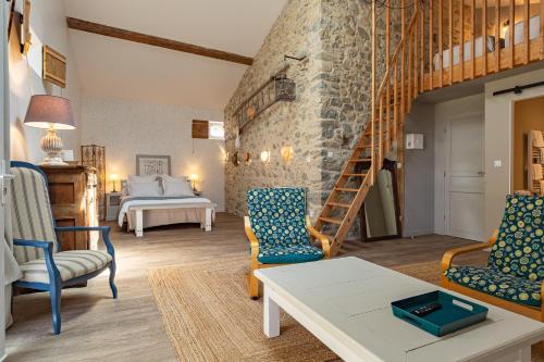 a living room with two chairs and a staircase at L'ormeau in Charols