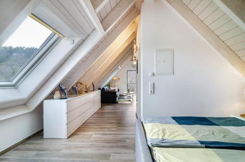an attic bedroom with a bed and windows at Appartment Naturblick in Stockach