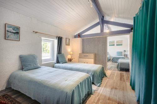 a bedroom with two beds and a window at Gite de l'Ocean in Genouillé