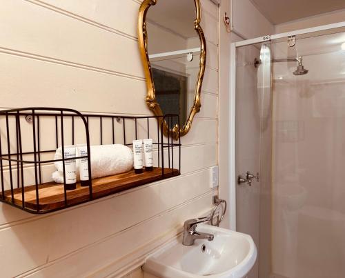 a bathroom with a mirror and a sink and a shower at Stonez Boutique Accommodation in Clunes