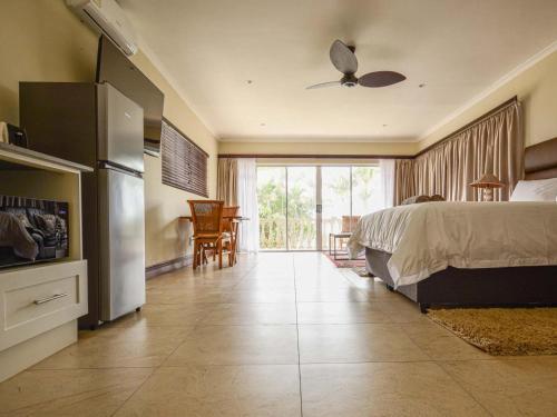 a bedroom with a bed and a sliding glass door at Driftwood on 10 La Lucia in Durban