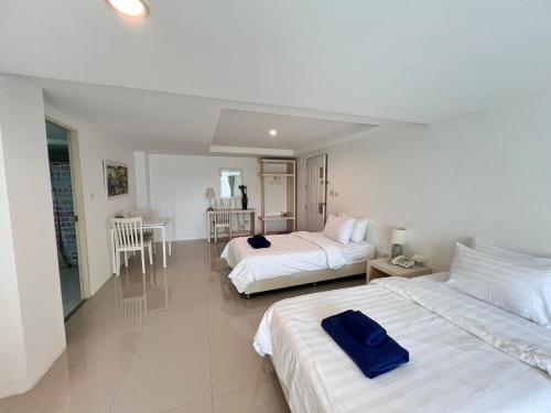 a hotel room with two beds and a table at The Terrace Hotel in Nakhon Si Thammarat