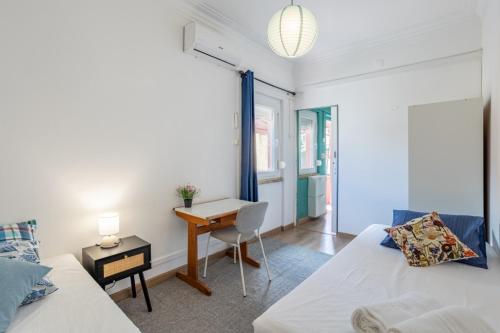a room with two beds and a desk and a table at AL Fancy Discoveries in Lisbon