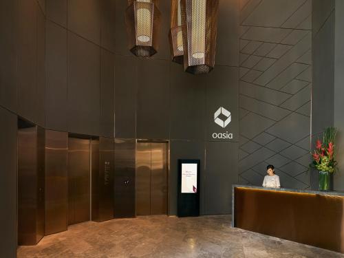 a woman standing in the lobby of a cisco building at Oasia Hotel Downtown, Singapore by Far East Hospitality in Singapore