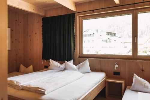 a bed in a room with a large window at Ferienhaus Islen in Mellau